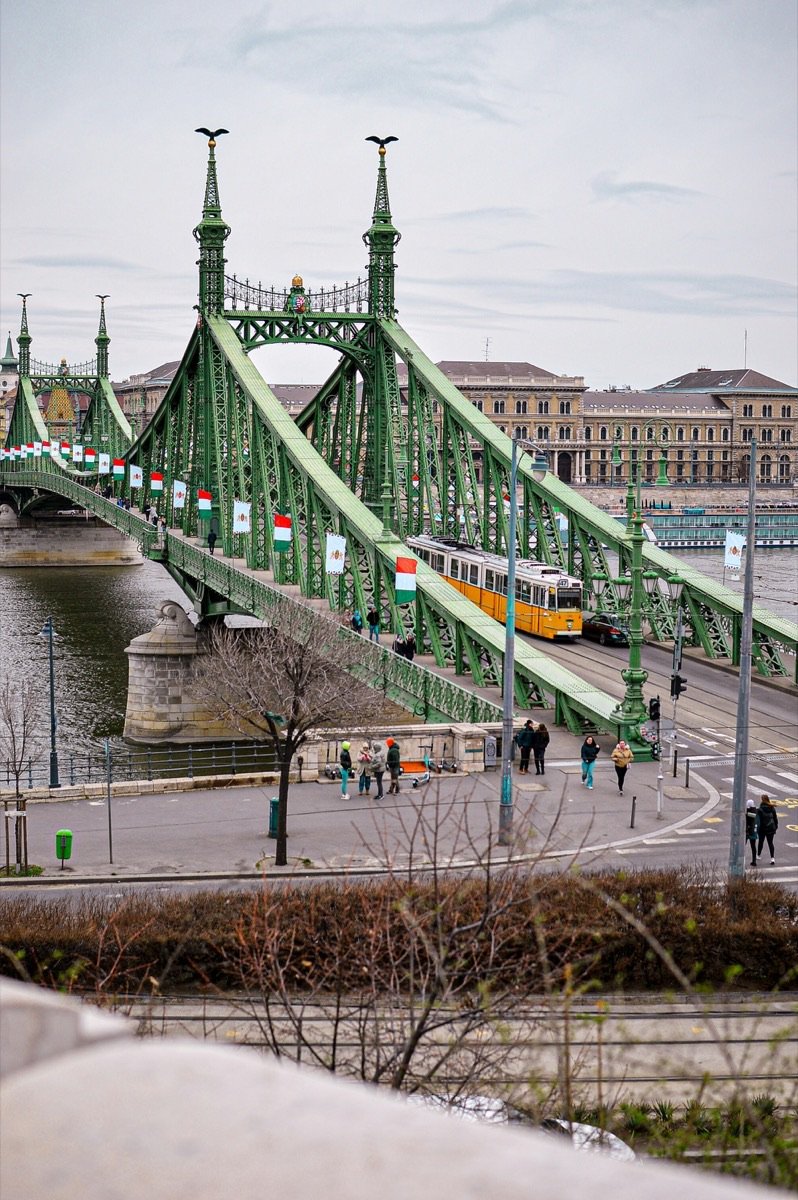 Liberty Bridge in Budapest with a yellow tram crossing the Danube